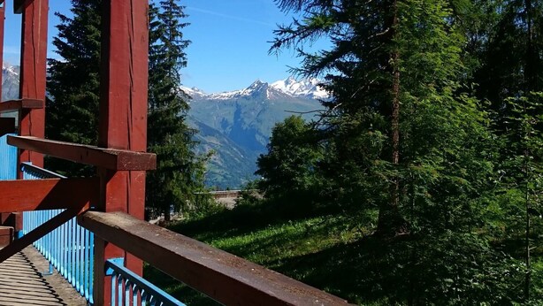 A wooden balcony with a view of snow-capped mountains and dense forest. - Studio for 4, ski-in/ski-out, Arc 1800 (Les Arcs 1800)