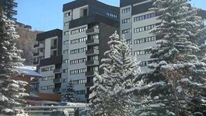 A multi-story building with a modern architectural design, featuring a mix of balconies and windows. - Bright apartment near slopes, balcony, pets allowed (Les Menuires)