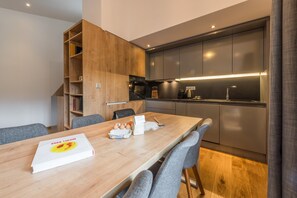 Uma cozinha moderna com armários cinza, uma mesa de jantar de madeira e um livro intitulado