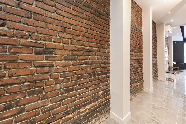 A modern interior with exposed brick walls and a polished floor.