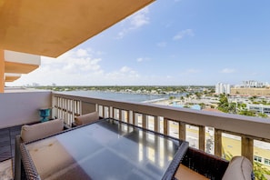 A balcony with a view of a body of water and buildings.