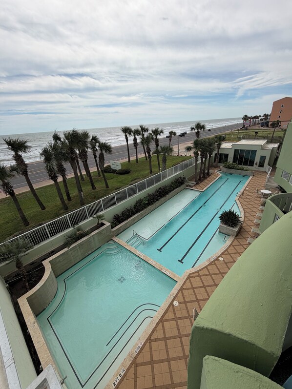 A swimming pool with a view of the ocean and a road.