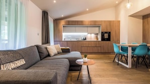 Un salon moderne avec un canapé, une petite table ronde et un coin repas avec des chaises.
