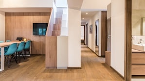Un intérieur moderne comprenant un coin repas, un escalier et une salle de bain.