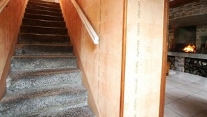 A staircase with stone steps leading to a wooden wall with a fireplace. - Family house with enclosed garden and spa near the beach (Saint-Germain-le-Gaillard)