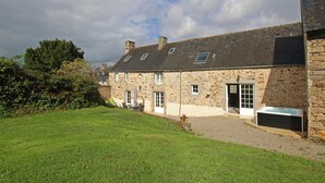 A stone building with multiple windows and a grassy lawn. - Family house with enclosed garden and spa near the beach (Saint-Germain-le-Gaillard)