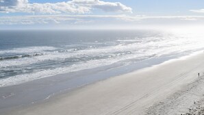Une plage dotée d’un large rivage sablonneux et de vagues douces.