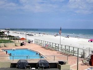 Un espace piscine offrant une vue sur la plage et l’océan.