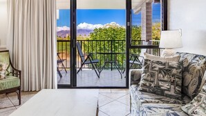 A room with a sliding glass door leading to a balcony with outdoor furniture.