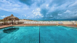 A clear blue pool with lounge chairs and a thatched-roof structure. - SUMMER SPECIAL Direct Beachfront!! MILLION View (Indian Shores)