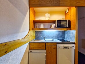 Cuina compacta amb microones, rentaplat i rentavaixelles.