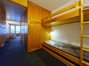 A bunk bed room with a wooden bunk bed, a desk with a chair, and a window. - Studio 5 people, ski-in/ski-out, near shops, pets allowed, Arc 1800 (Les Arcs 1800)