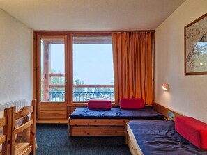 A room with a bed, a chair, and a window with curtains. - Studio 5 people, ski-in/ski-out, near shops, pets allowed, Arc 1800 (Les Arcs 1800)
