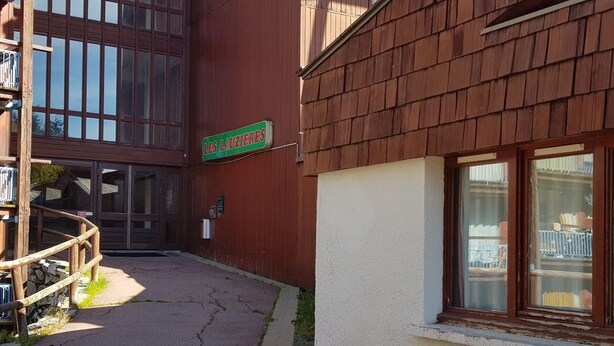 Un bâtiment sur lequel on peut lire l’inscription « LES LAUZIÈRES », et un escalier en bois qui mène à une porte.