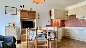 A compact living space with a dining area, kitchenette, and a TV mounted on the wall. - 2-room apartment, beach access, parking, sleeps 4 - Argelès-sur-Mer (Argelès-sur-Mer)