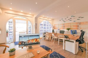 Work and unwind in a spacious office with a large desk, comfortable seating area, and display wall.