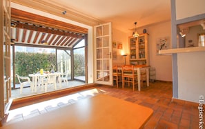 Enjoy meals at the dining table with outdoor access, a kitchenette, and a spacious living area.