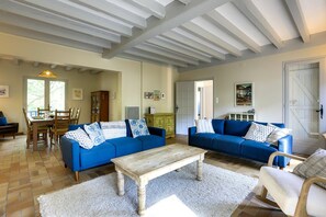 A spacious living room with two blue sofas, a wooden coffee table, and a white rug. - Hossegor Lake, 10 pers Villa (SEIGNOSSE)