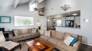 A spacious living room with a large sectional sofa, a wooden coffee table, and a ceiling fan. - Pelicans Place LCV23 has great views from 2 decks, and is close to white sandy b (Port Aransas)