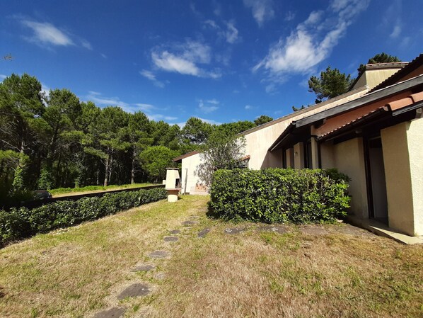 A building with a traditional architectural style, a paved pathway leading to the entrance, and a well-maintained garden area.