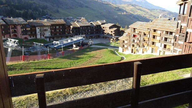 Vista de un hotel con varias construcciones, un telesilla y un paisaje montañoso.