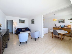 Um apartamento moderno com sala de estar, área de jantar e cozinha compacta.