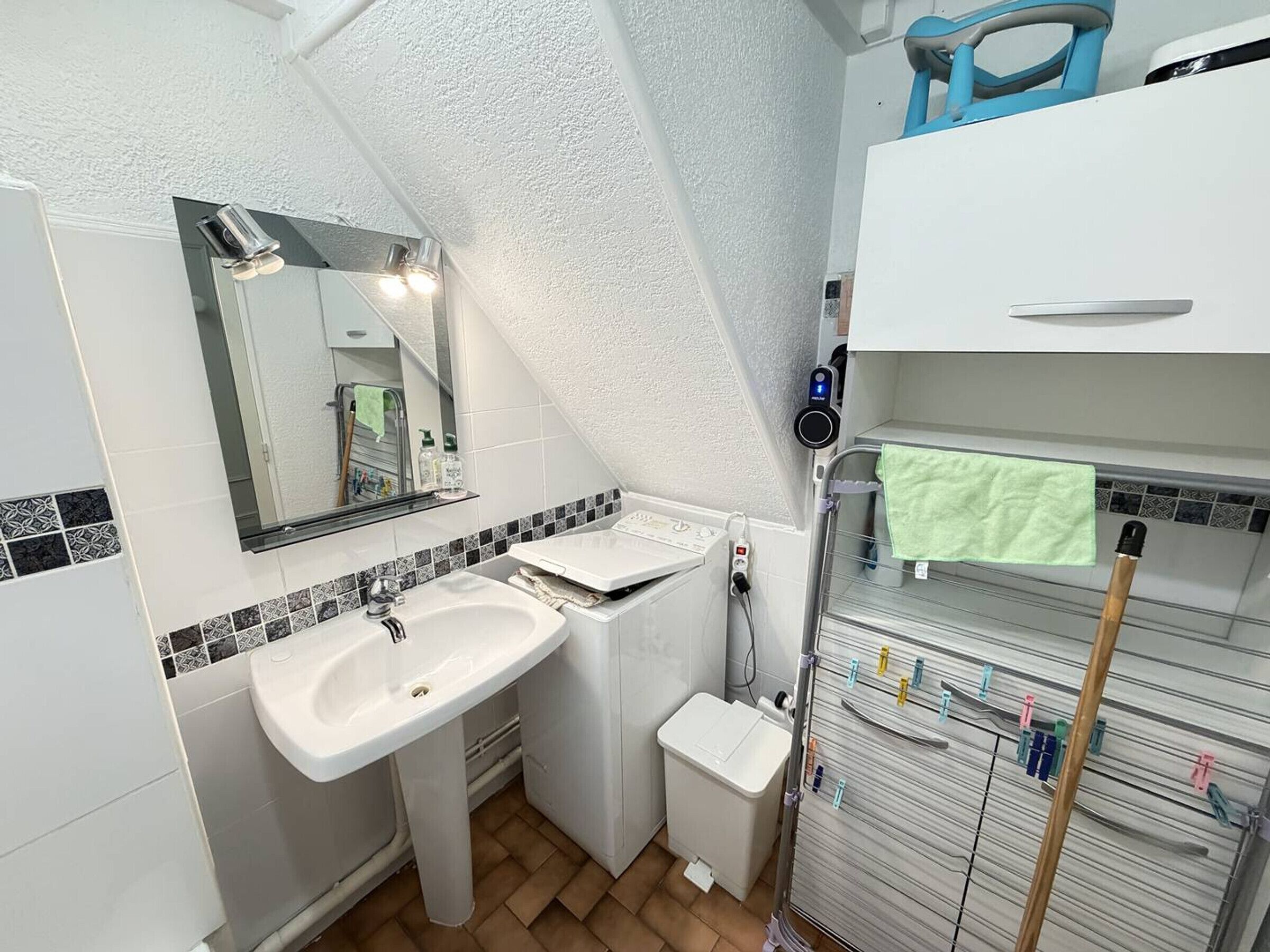 Un baño con lavabo, espejo, toallero y retrete.