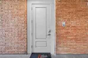 The entry to condo #204 features a secure keypad lock and charming exposed brick, marking the start of your urban retreat. - This fabulous upscale condo is located right on the ship channel and in the hear (Port Aransas)
