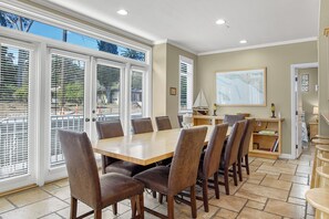 Un comedor con una mesa grande y sillas, una decoración con forma de velero y un mapa en la pared.