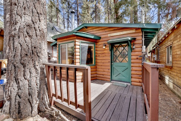 Welcoming cabin entry surrounded by towering pine trees, offering fresh mountain air and a peaceful forest setting—the perfect first impression for your Big Bear Lake getaway.