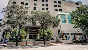 A high-rise hotel with a modern design, featuring a prominent entrance and a clear sky. - Luxury Penthouse w/Private Rooftop Terrace in Coconut Grove Hotel! (Miami)