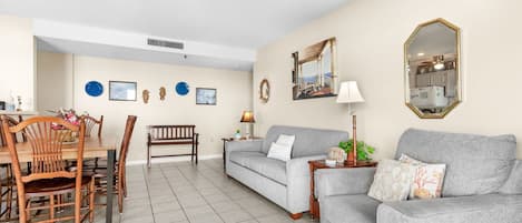 A living room with a dining table, two sofas, and a coffee table.