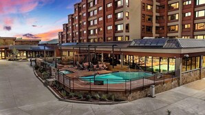 A modern hotel with a rooftop pool area, outdoor seating, and a view of the surrounding buildings. - Luxury Ski-In Penthouse- Walk to Main St (Breckenridge)