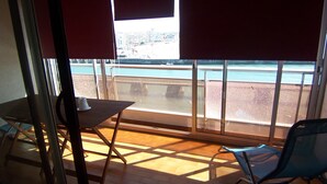 A room with a view of a beach and ocean through large windows. - Apartment with canal view, garage and wifi (Les Sables-d'Olonne)