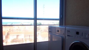 A laundry room with a large window, a washing machine, and a dryer. - Apartment with canal view, garage and wifi (Les Sables-d'Olonne)