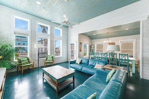 A spacious living room with a blue leather sofa, wooden coffee table, and green chairs. - Come and play at our Blue Hawaiian Beach house! Close to the beach! The perfect (Port Aransas)
