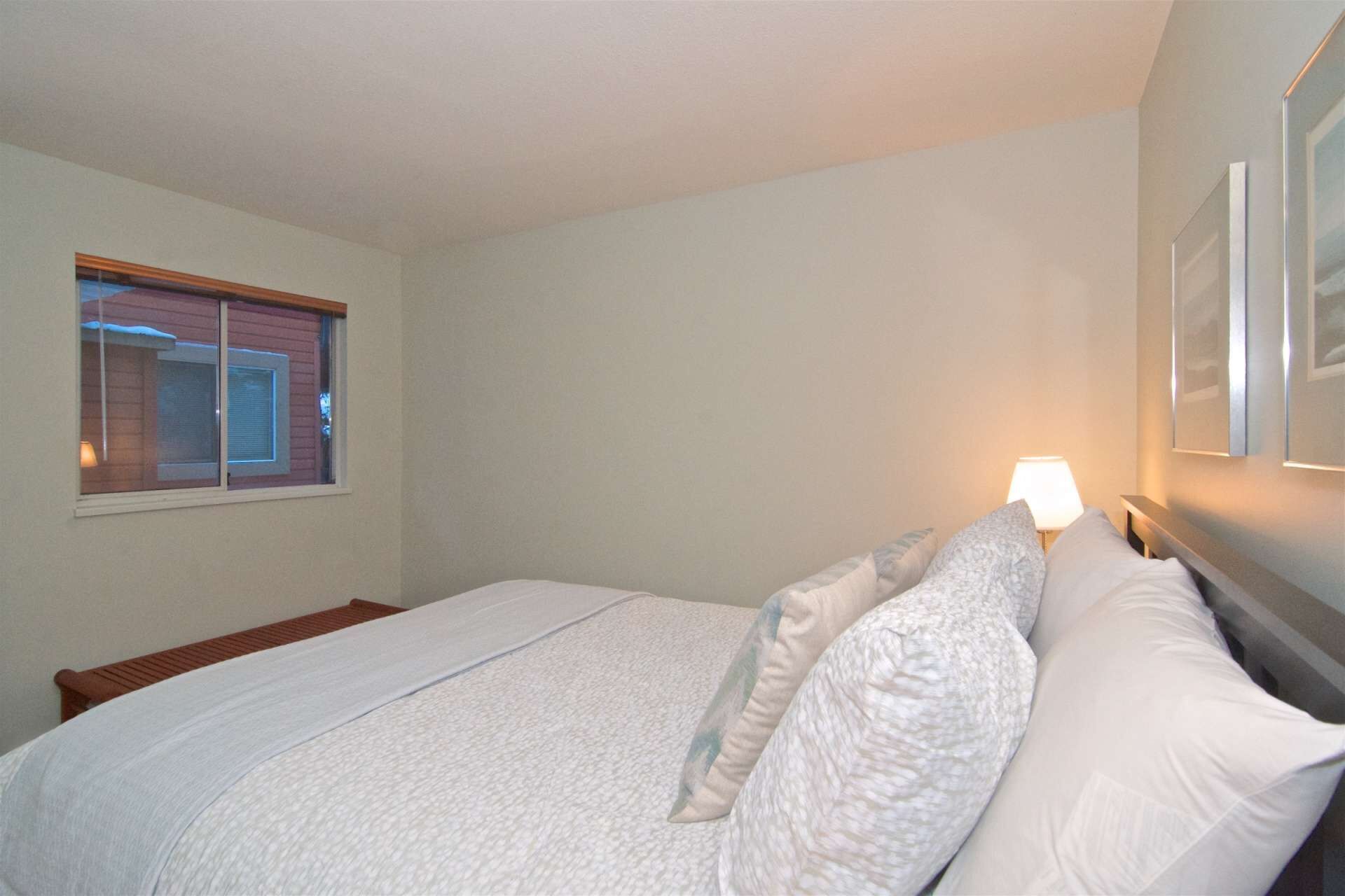 Una camera da letto con un letto, una finestra e una lampada a parete.
