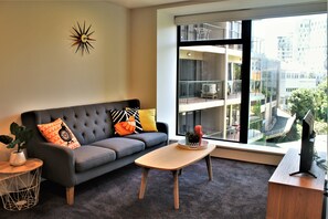 Apartamento urbano, 2 camas Queen, vista para a cidade | Área de estar | TV de tela plana