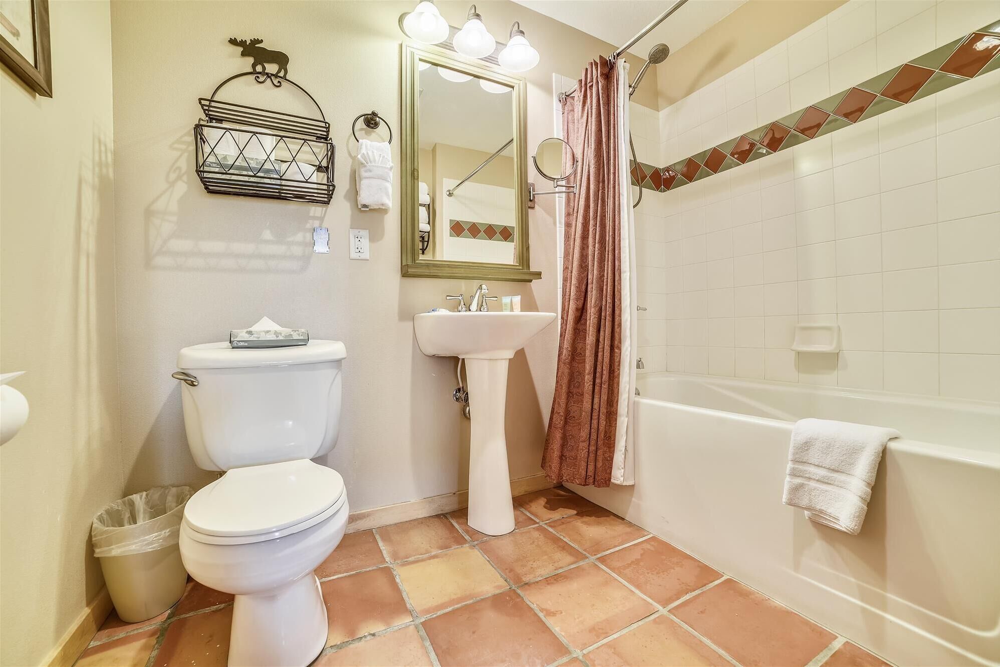A bathroom with a toilet, sink, and bathtub.