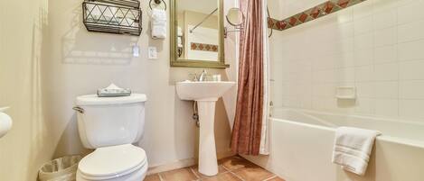 A bathroom with a toilet, sink, and bathtub.