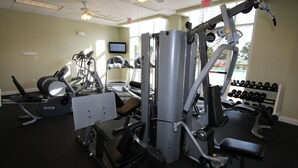 A gym with various exercise equipment, including treadmills, weight machines, and dumbbells. - Ariel Dunes 1- 605 in Seascape Resort. New bathroom! Great rates! (Miramar Beach)
