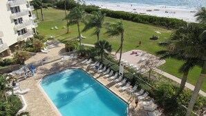 A pool area with lounge chairs and a view of the beach. - Escape To Beachfront Getaway Vacation Condo At Bargain Price! Heated Resort Pool! (Fort Myers Beach)