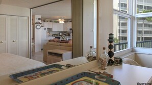 A compact living space with a kitchenette, a dining area, and a view of a balcony. - Escape To Beachfront Getaway Vacation Condo At Bargain Price! Heated Resort Pool! (Fort Myers Beach)