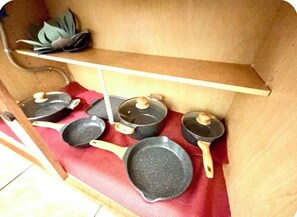 A kitchen shelf with various cookware items.