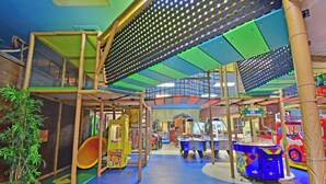 A children's play area with climbing structures, a small slide, and arcade machines. - Town Home in Gated Resort with Lazy River & Waterslide Close to Attractions (Davenport)