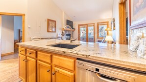 A kitchen with wooden cabinets, a stainless steel sink, and a dishwasher.