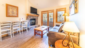 A living room with a fireplace, wooden furniture, and a television.