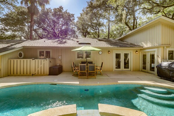 Enjoy outdoor dining and relaxation by the pool on the spacious deck.