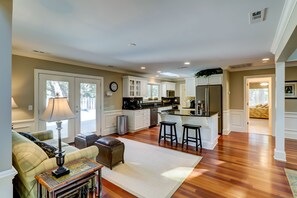 Relax in a spacious living area with a comfortable sofa, coffee table, and dining bar, perfect for socializing or enjoying a meal.