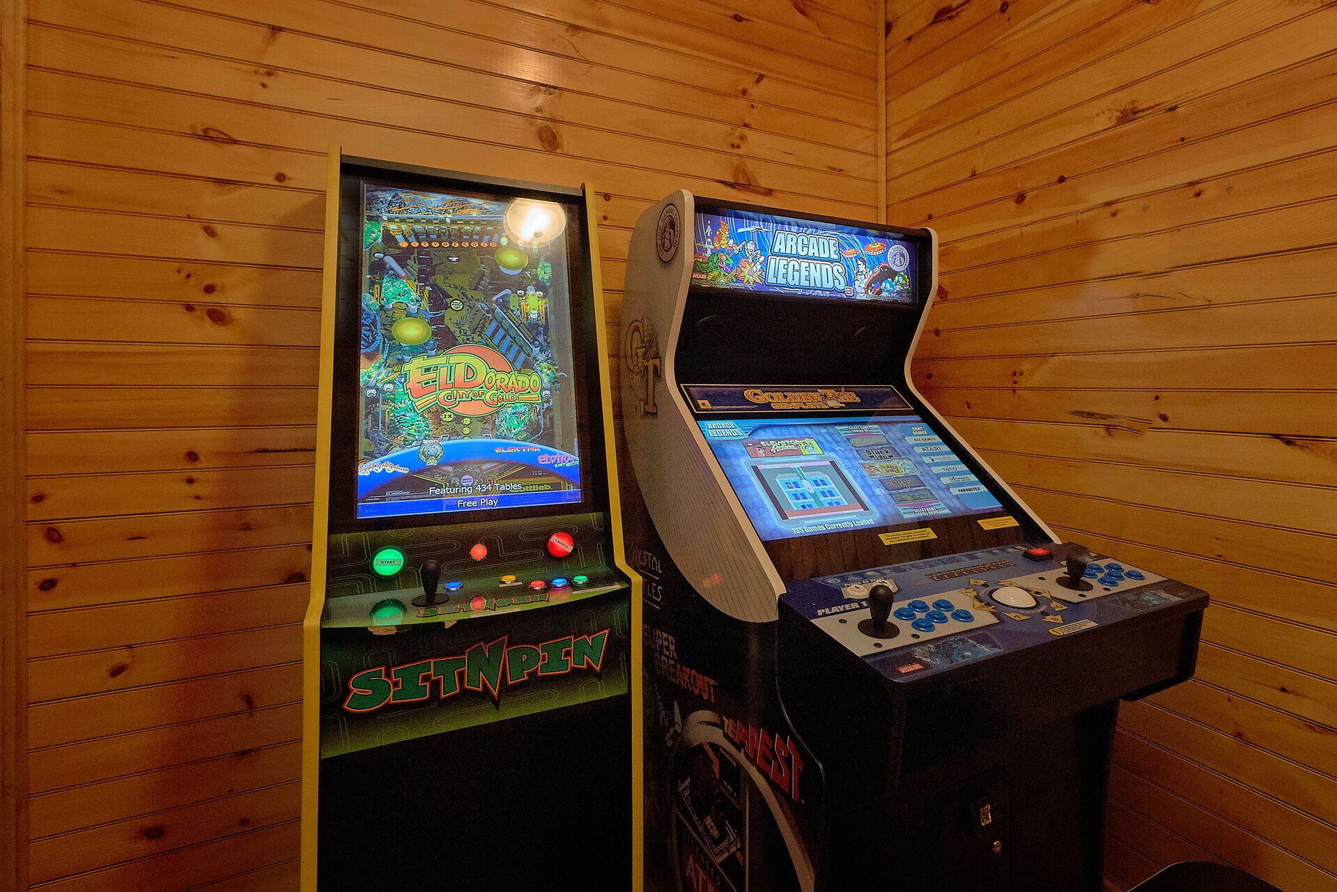 Two arcade machines in a wooden-paneled room.
